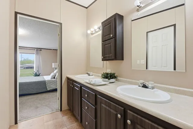 a en suite bathroom with a granite countertop sink and a mirror