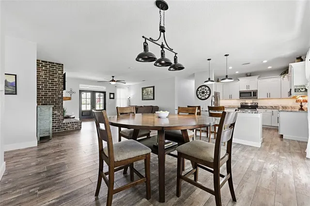 a view of a dining room and livingroom with furniture wooden floor a chandelier
