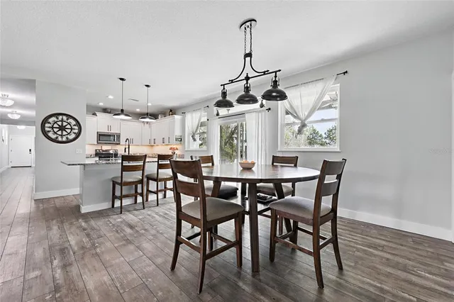 a bedroom with a bed a chandelier and dresser