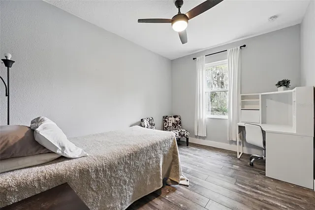 a bedroom with a bed and dresser with mirror