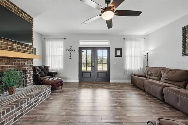 a living room with furniture floor to ceiling window and a flat screen tv