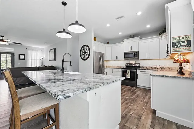 a kitchen with kitchen island stainless steel appliances a stove a sink and a refrigerator