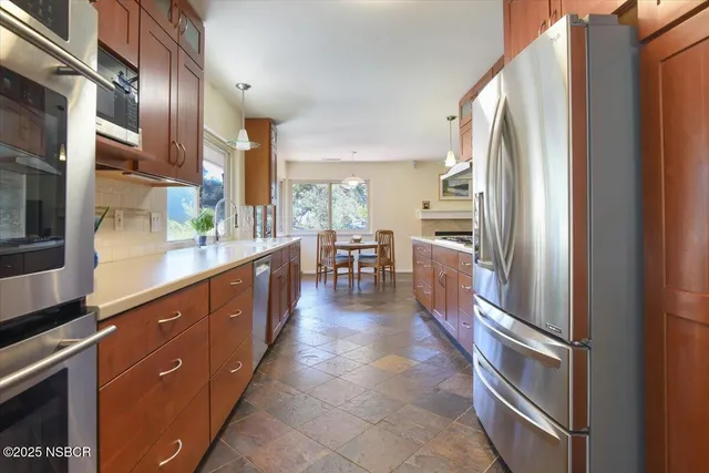 a kitchen with stainless steel appliances granite countertop a refrigerator and a sink