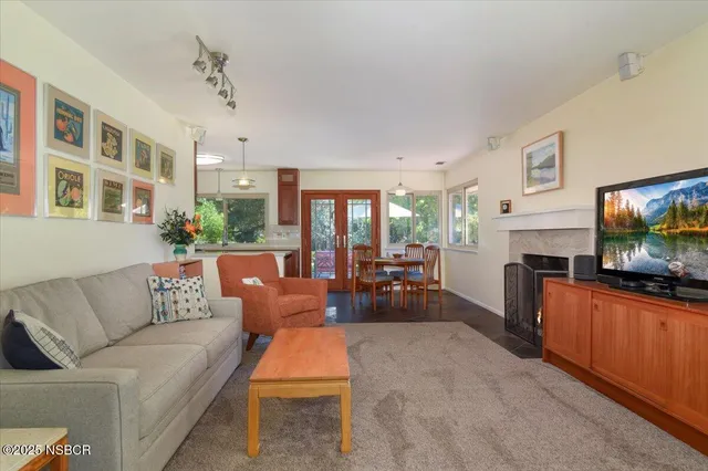 a living room with furniture a fireplace and a flat screen tv