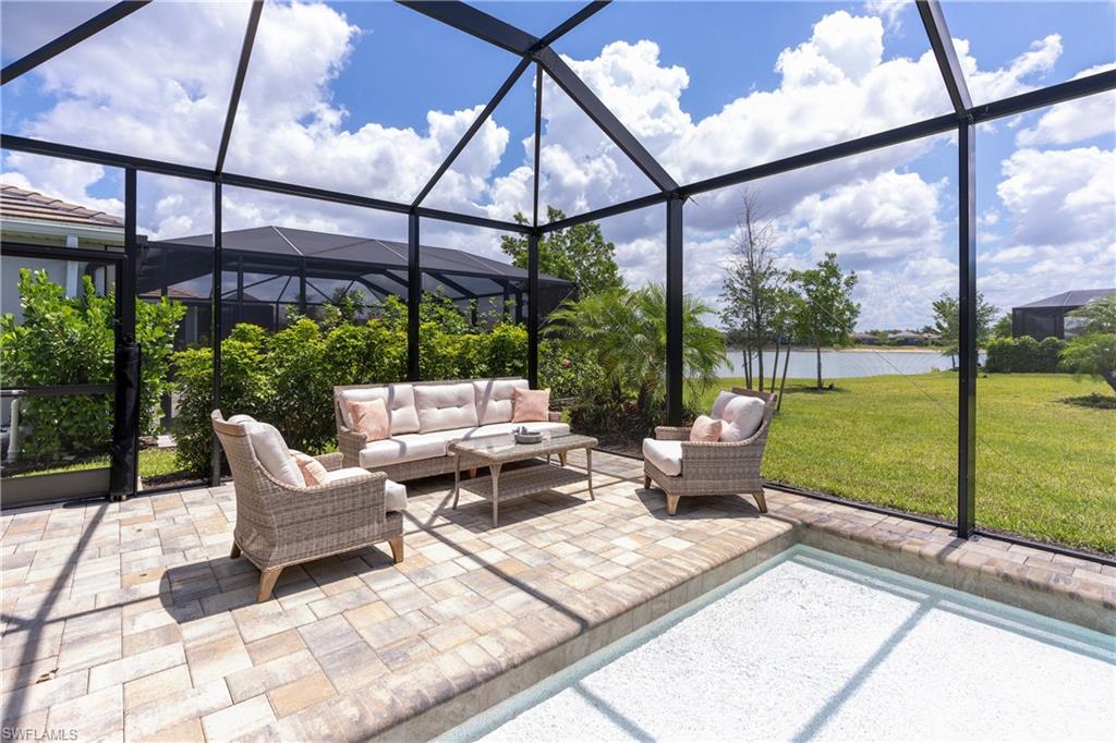 14488 Stillwater Way Naples, FL 34114 - Photo 12 of 37 a view of a patio with a table chairs and a floor to ceiling window