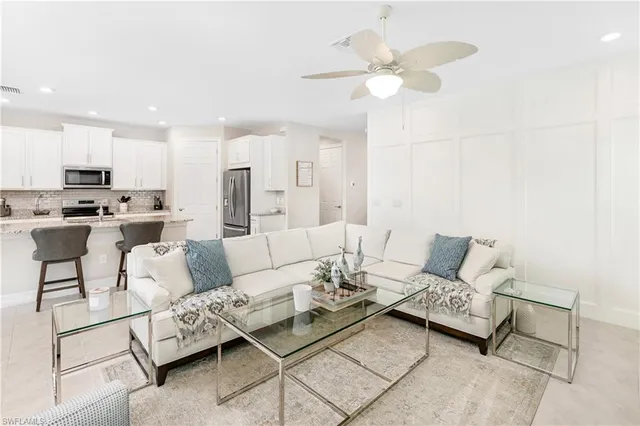 a living room with furniture and a view of kitchen