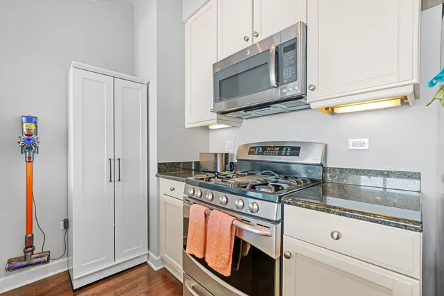 a kitchen with stainless steel appliances granite countertop a stove and a microwave