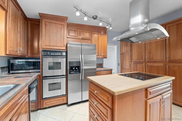 a kitchen with stainless steel appliances granite countertop a sink a stove and a refrigerator