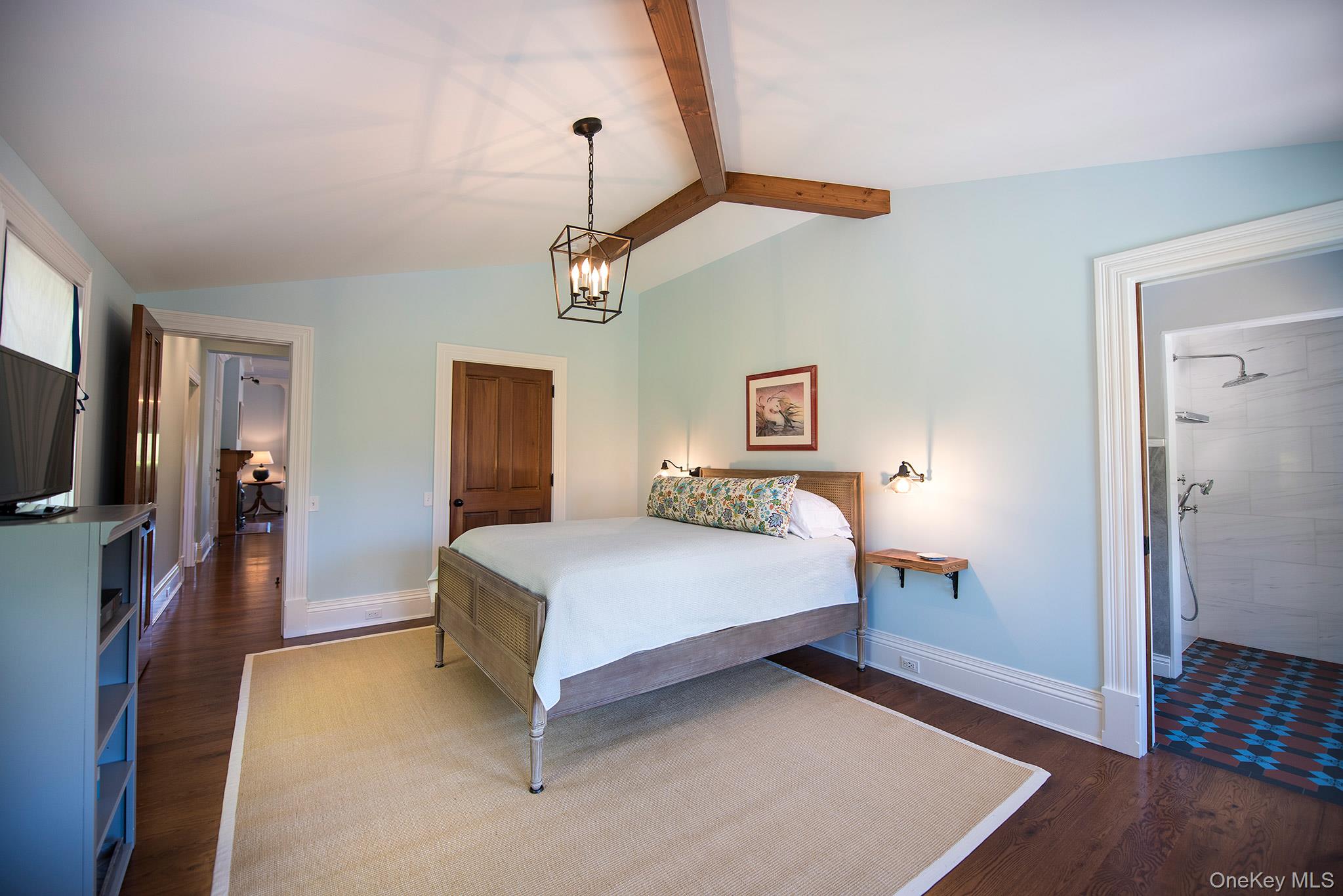 106 Old Depot Road Quogue, NY 11959 - Photo 18 of 34 a bedroom with a bed and a flat screen tv