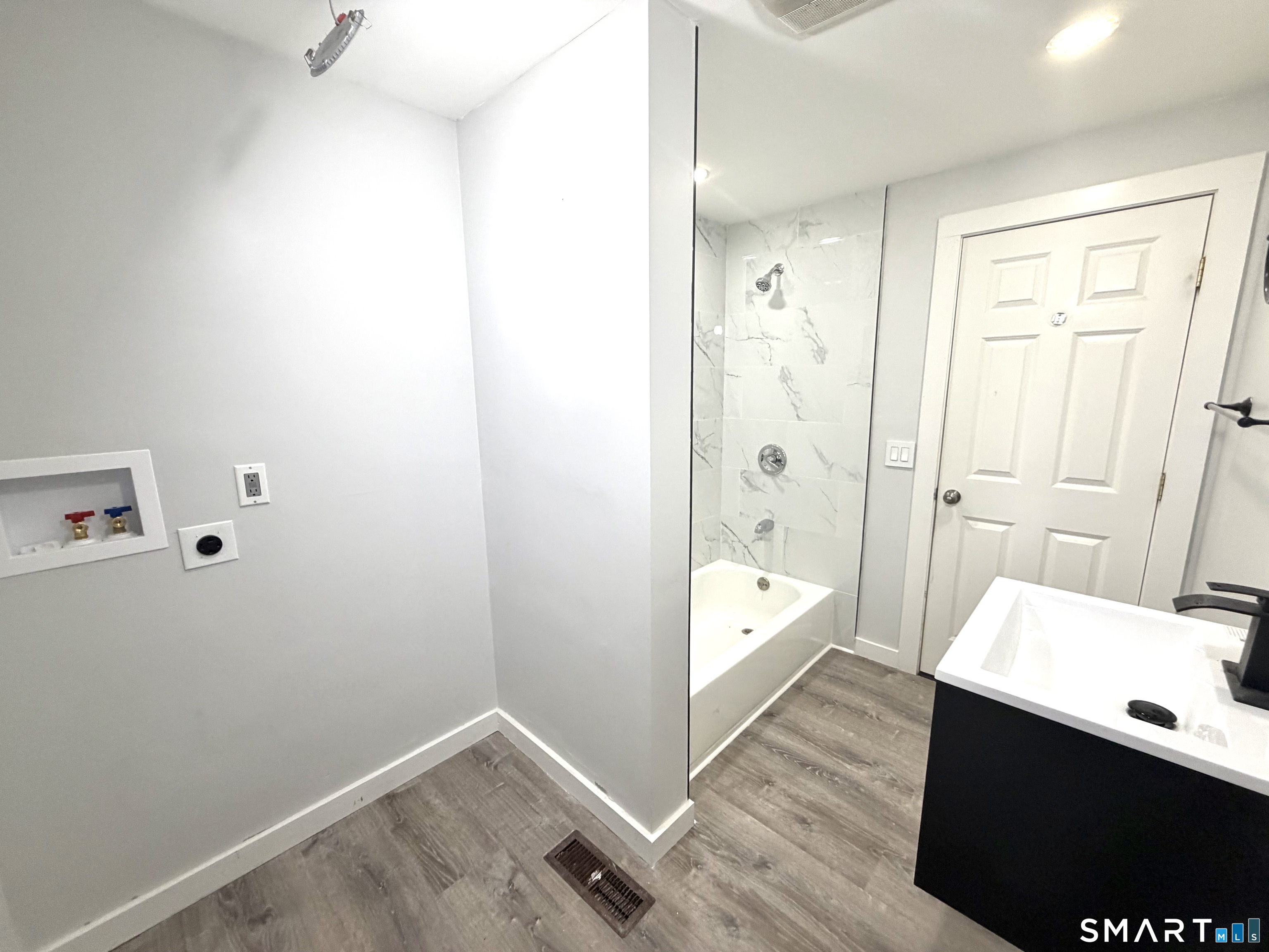 184 Park Street Bridgeport, CT 06608 - Photo 11 of 12 a bathroom with a tub shower vanity and a sink