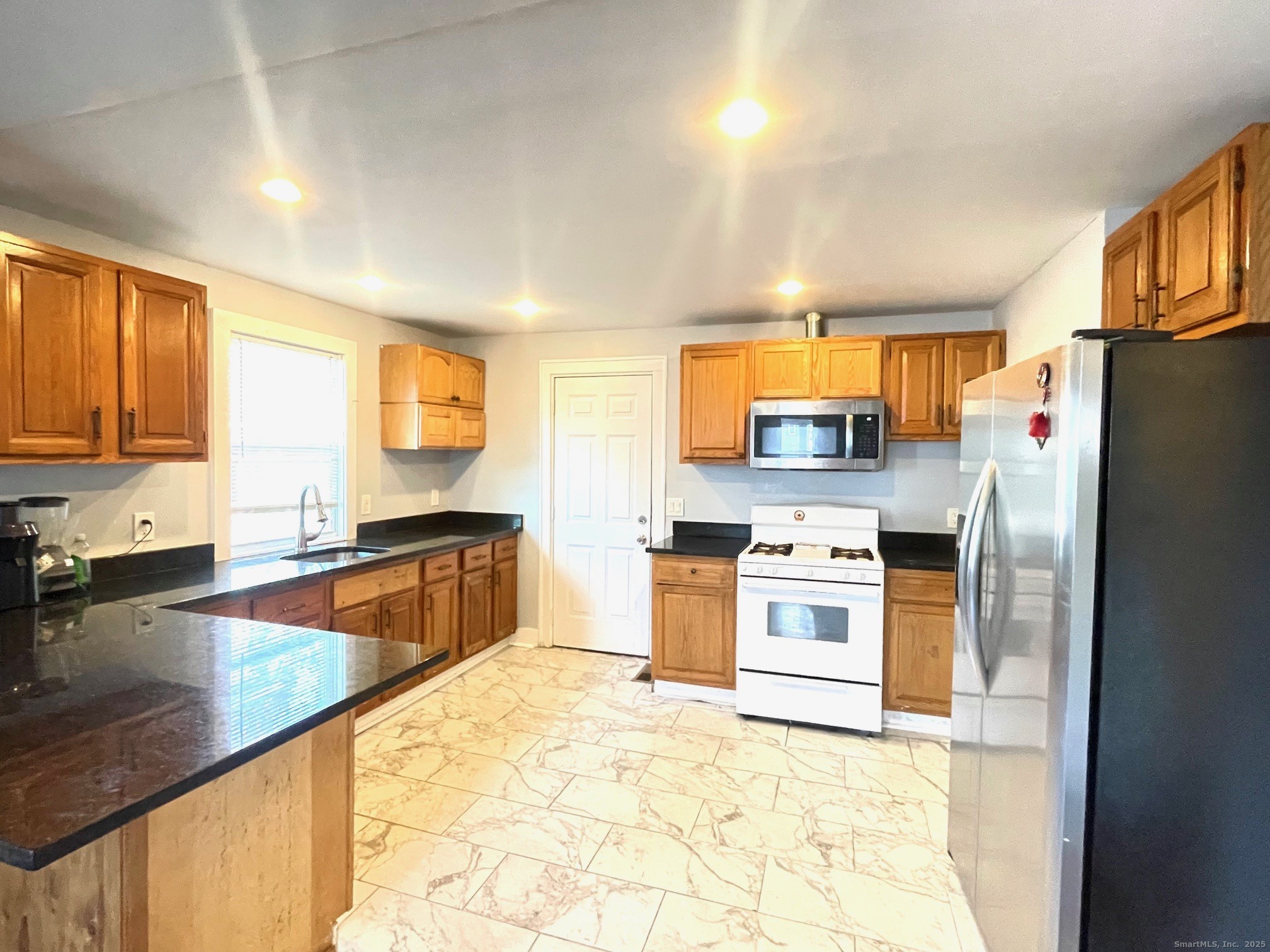 184 Park Street Bridgeport, CT 06608 - Photo 4 of 7 a kitchen with stainless steel appliances granite countertop a stove a refrigerator a sink a stove and island