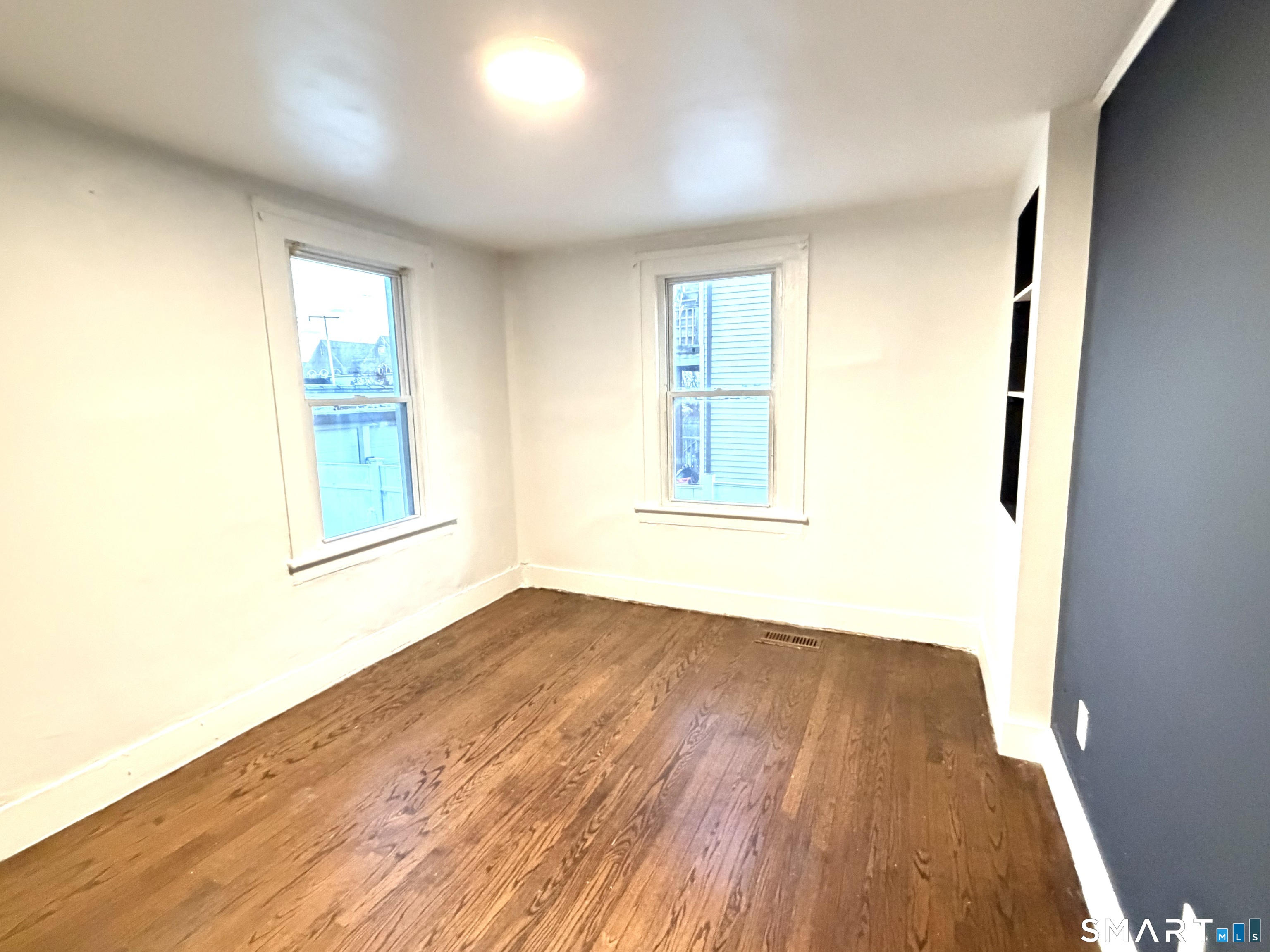 184 Park Street Bridgeport, CT 06608 - Photo 6 of 11 an empty room with wooden floor and windows