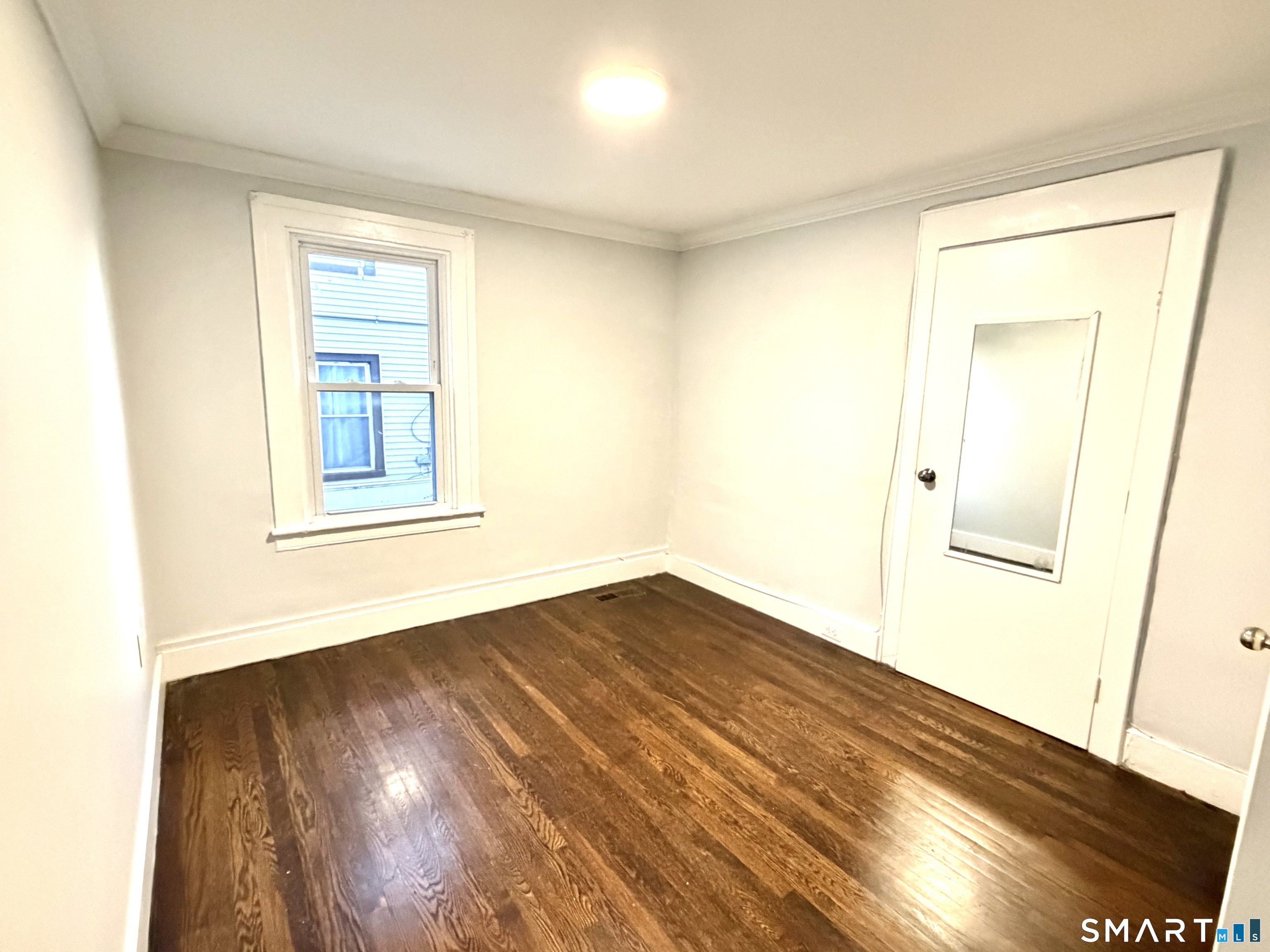 184 Park Street Bridgeport, CT 06608 - Photo 7 of 11 a view of an empty room with wooden floor and a window
