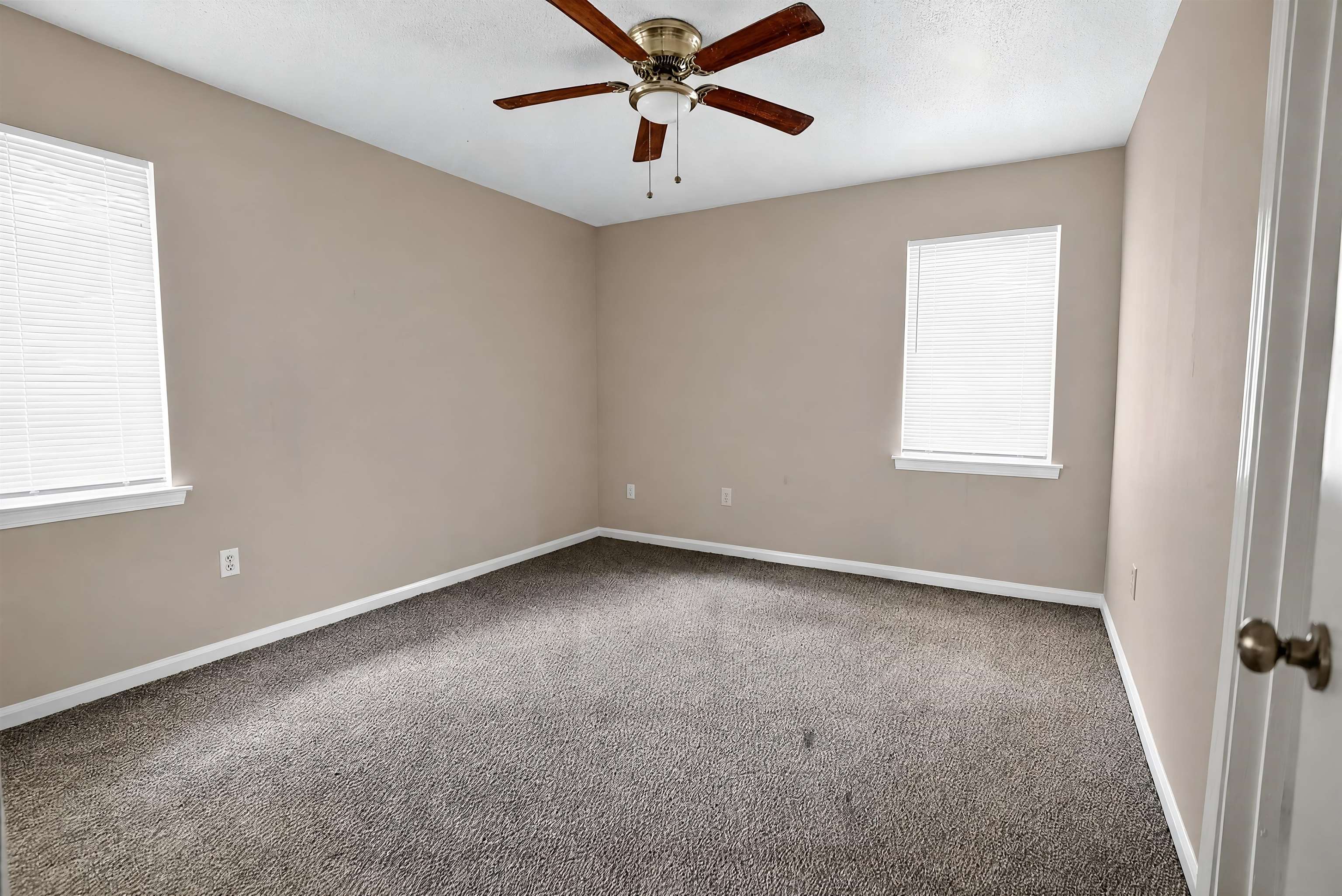 4530 Spring Valley Drive Memphis, TN 38128 - Photo 9 of 15 Spacious room featuring neutral paint, gray carpeting, a ceiling fan with wood-finish blades, and two windows with blinds