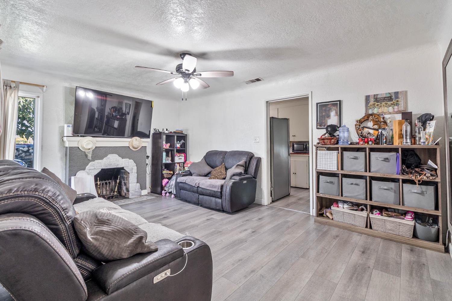 792 Grove Avenue Gustine, CA 95322 - Photo 11 of 32 a living room with furniture a fireplace and a chandelier