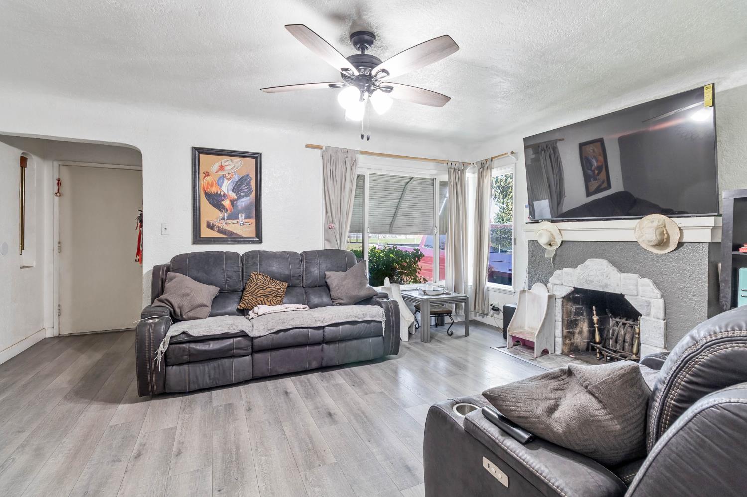 792 Grove Avenue Gustine, CA 95322 - Photo 14 of 32 a living room with furniture a fireplace and a flat screen tv