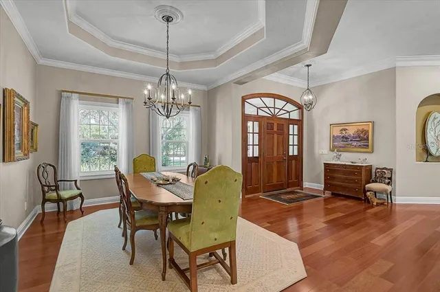 a dining room with furniture a chandelier and wooden floor