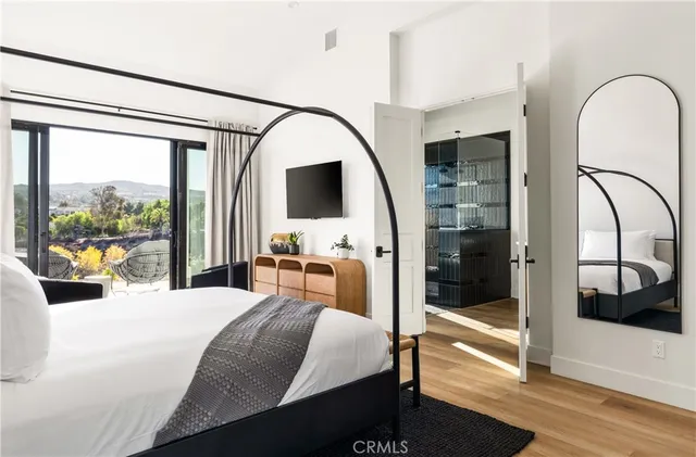 a bedroom with a large bed and a chandelier