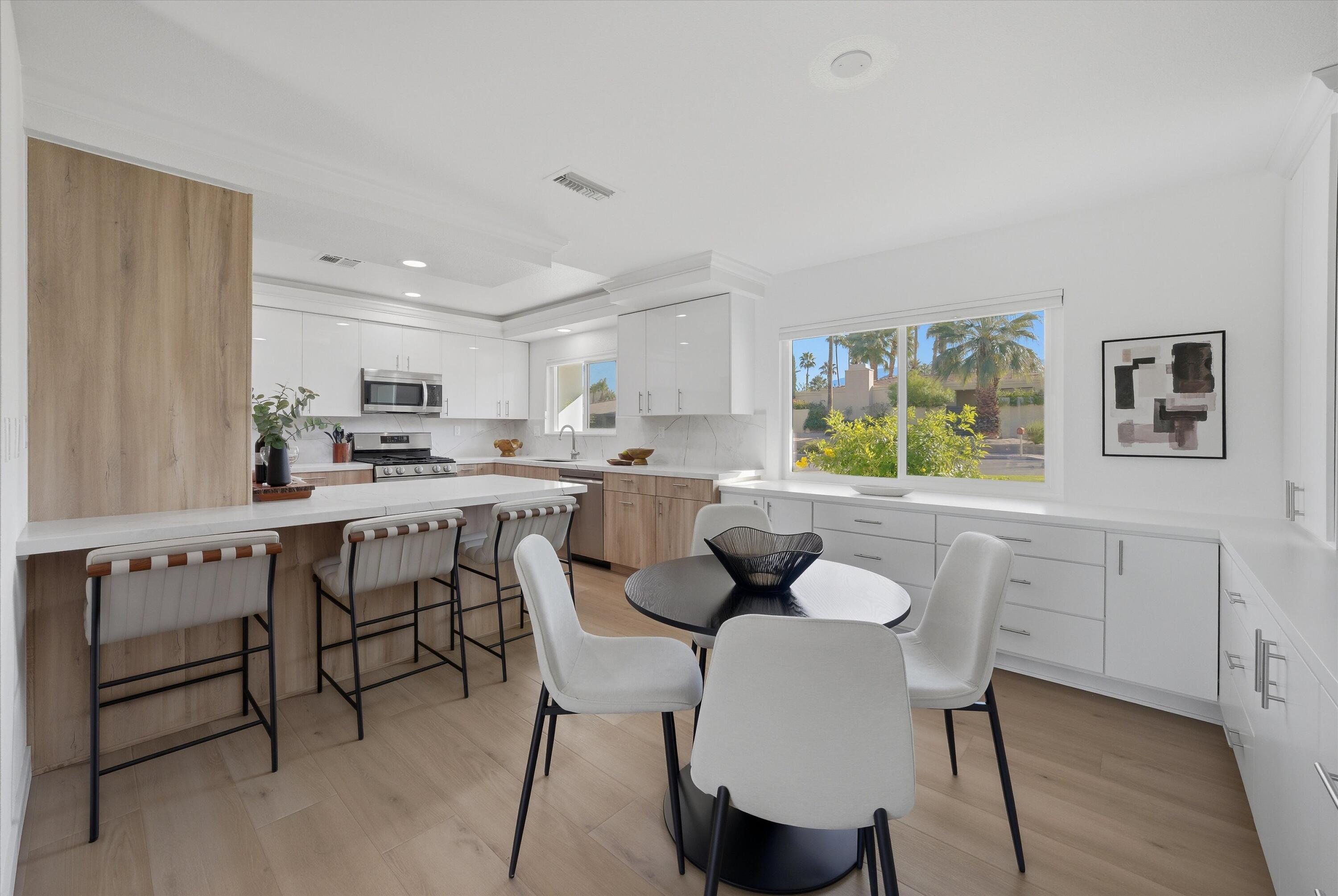 72920 Somera Road Palm Desert, CA 92260 - Photo 15 of 49 a kitchen with a dining table chairs and refrigerator