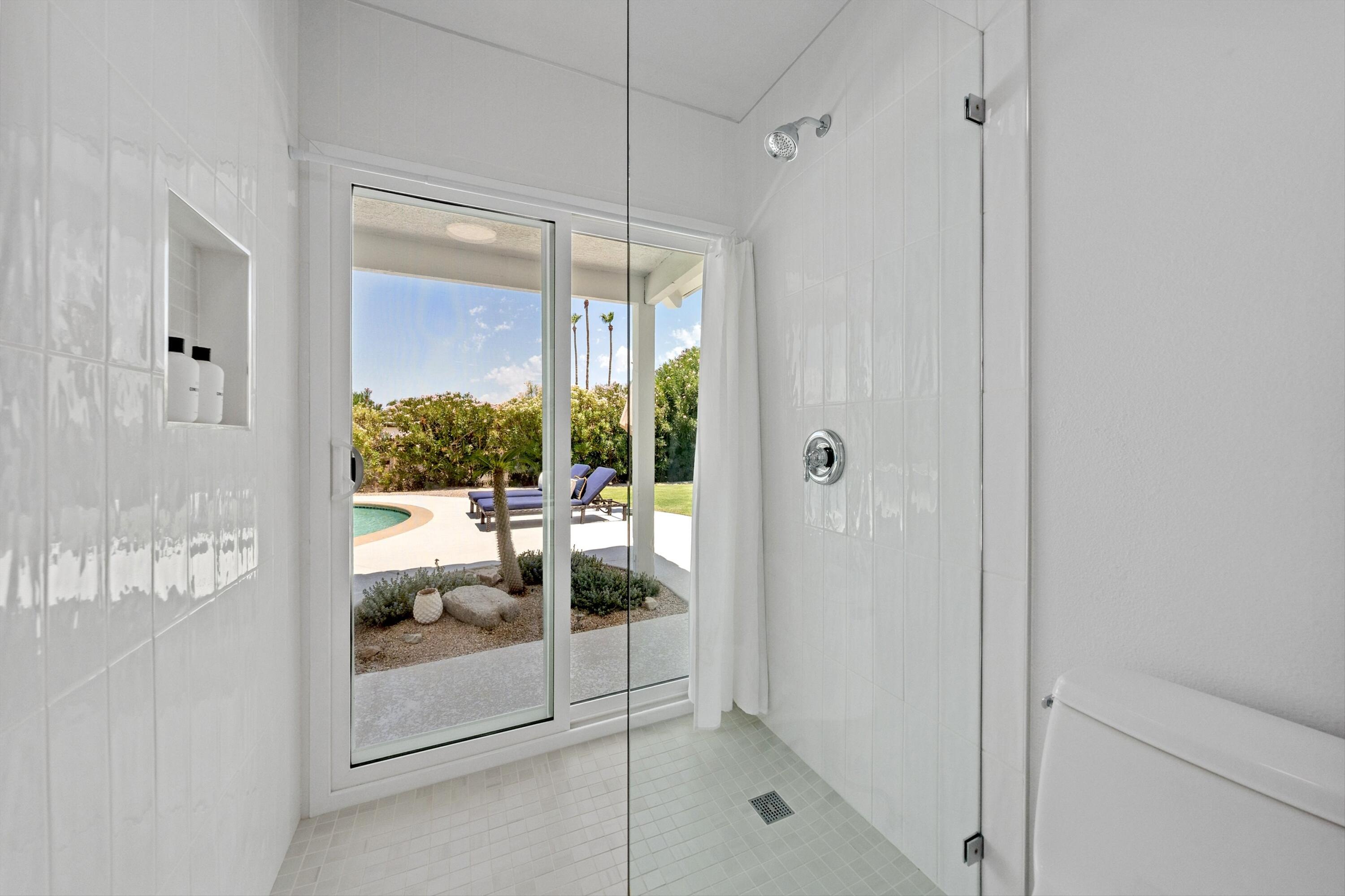 72920 Somera Road Palm Desert, CA 92260 - Photo 20 of 49 a bathroom with a glass shower door and a glass door