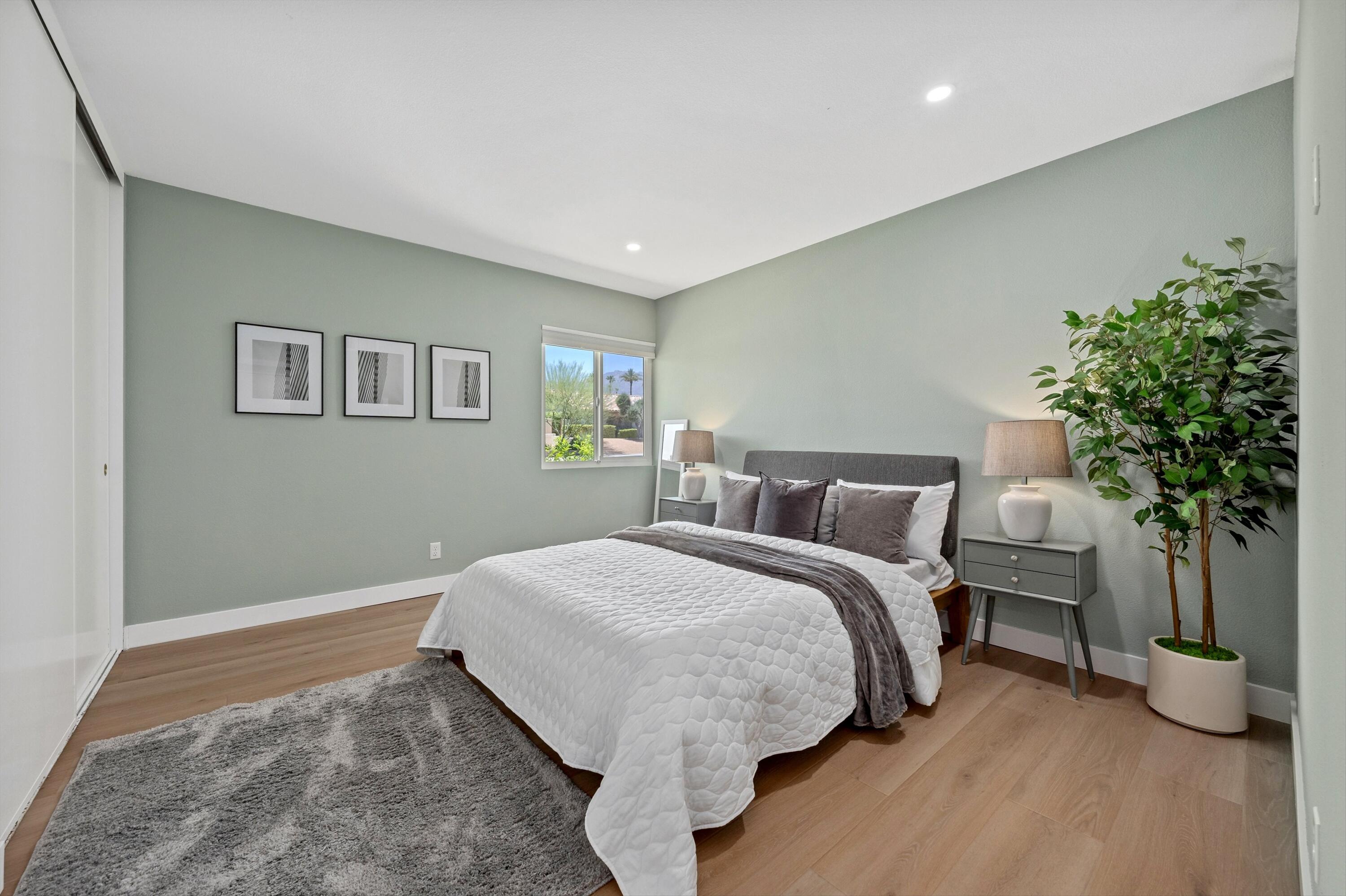 72920 Somera Road Palm Desert, CA 92260 - Photo 21 of 49 a spacious bedroom with a bed and a plant