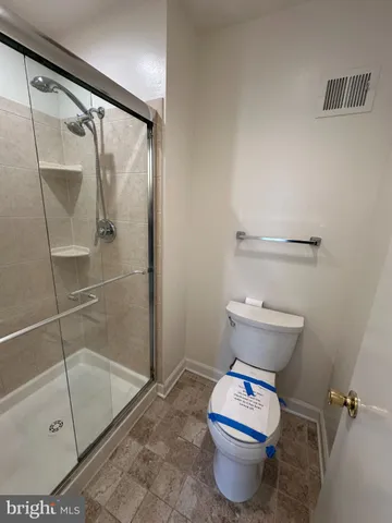 a bathroom with a toilet and a shower