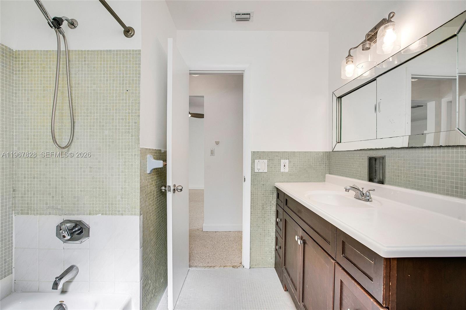 9372 Abbott Avenue Surfside, FL 33154 - Photo 17 of 25 a bathroom with a sink vanity granite tub shower and mirror