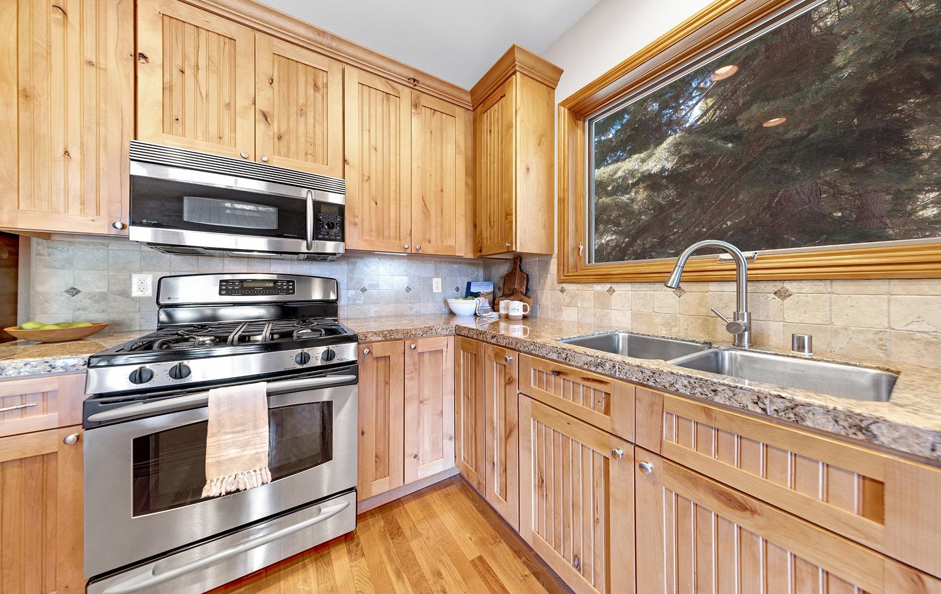 627 Deep Forest Road Lake Almanor, CA 96137 - Photo 10 of 29 a kitchen with stainless steel appliances granite countertop a stove a sink and a microwave