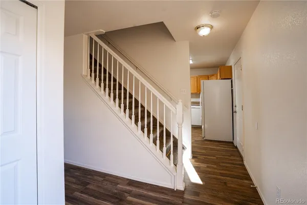 a view of a hallway with wooden floor and staircase
