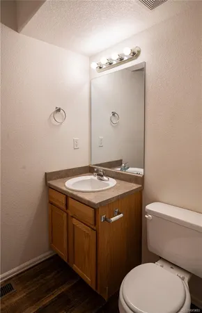 a bathroom with a granite countertop toilet sink and mirror