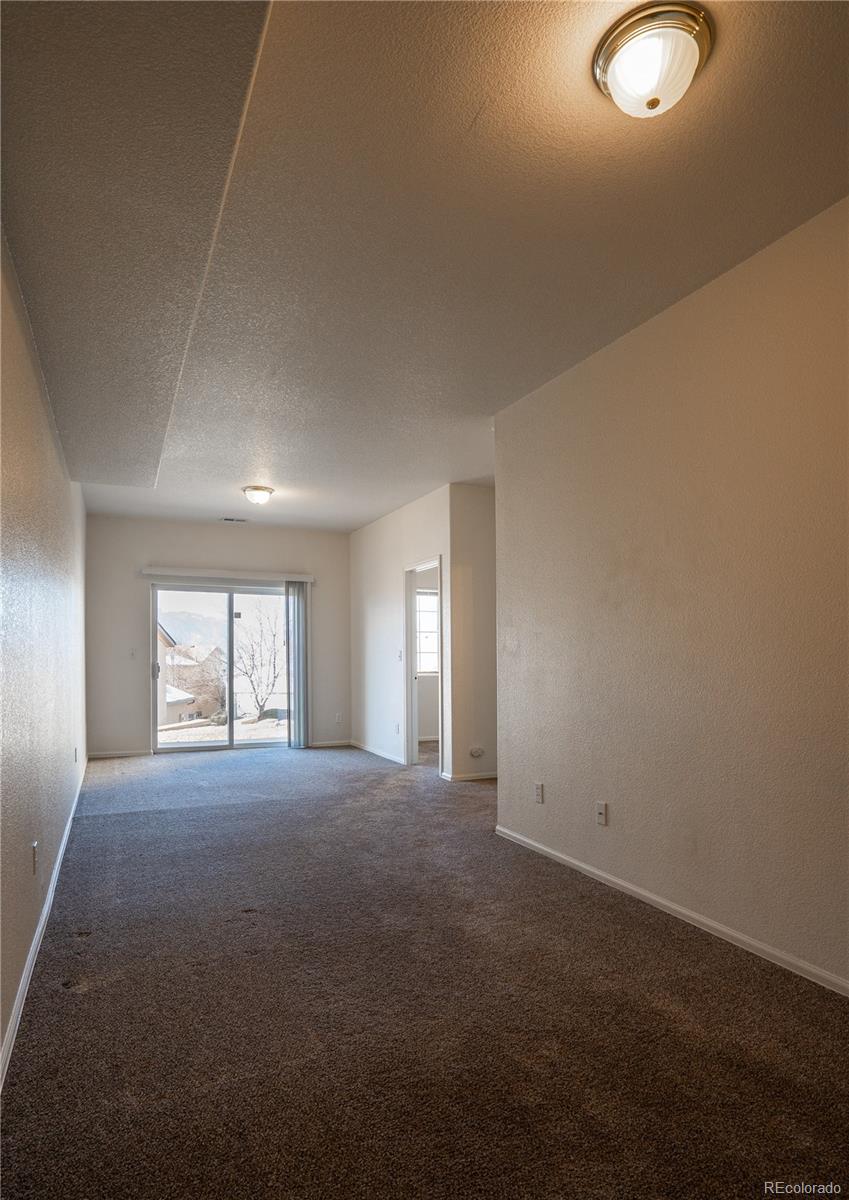 672 Bosque Vista Point, Unit 26 Colorado Springs, CO 80916 - Photo 22 of 25 an empty room with windows and yard