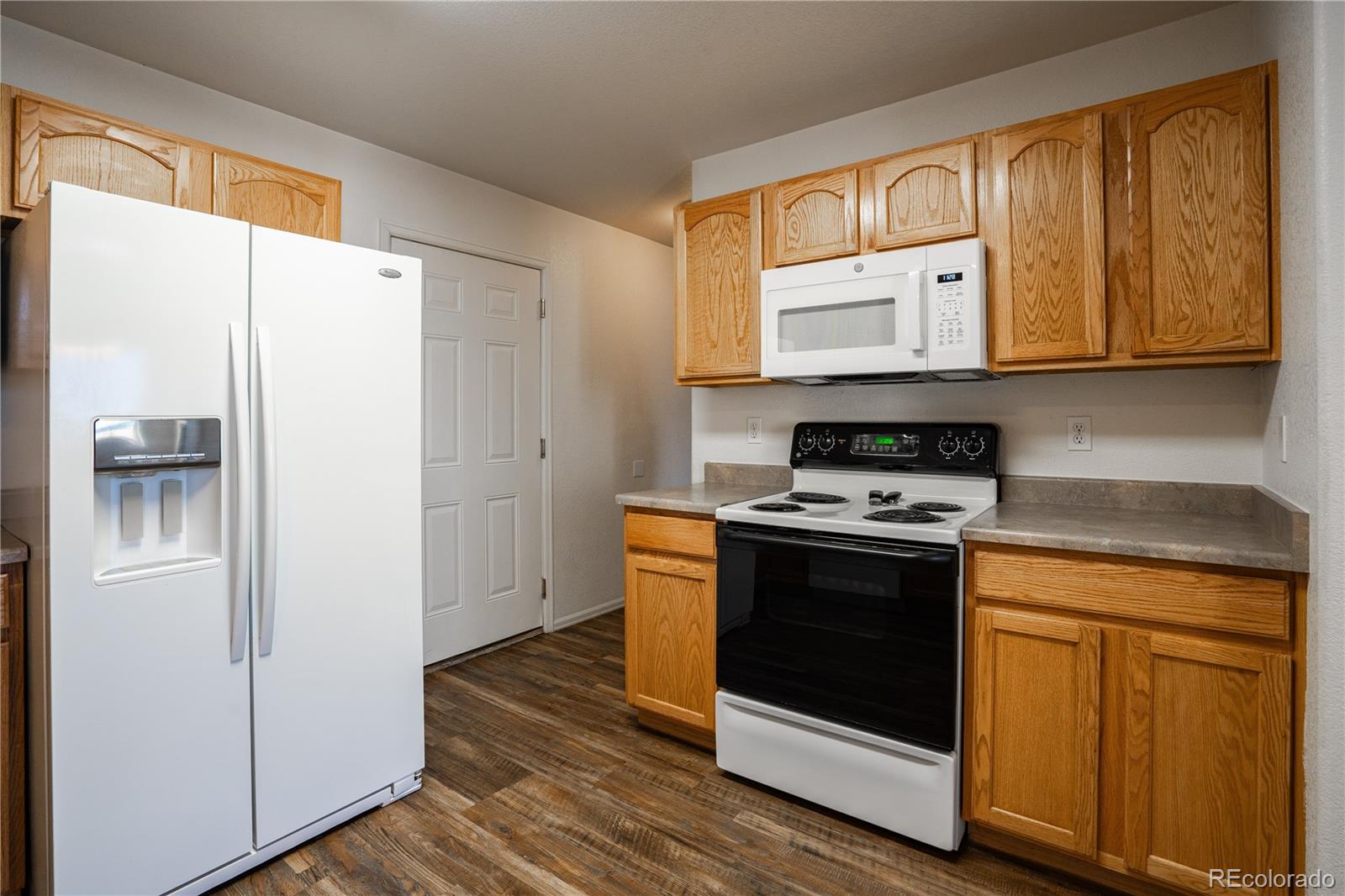 672 Bosque Vista Point, Unit 26 Colorado Springs, CO 80916 - Photo 5 of 25 a kitchen with stainless steel appliances granite countertop a stove a refrigerator and a cabinets