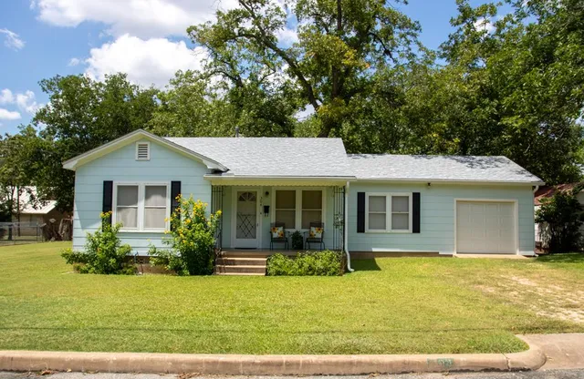 a front view of house with yard and green space