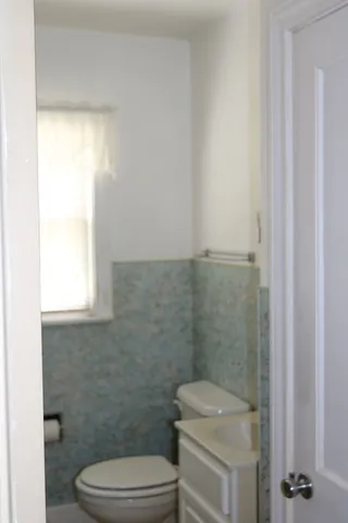 a view of a utility room with closet and wooden floor