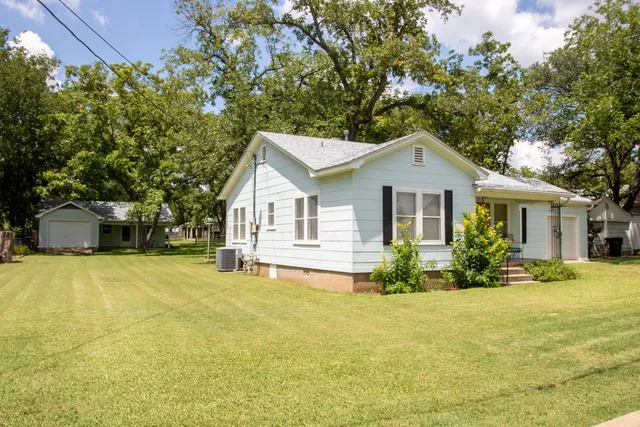 a front view of a house with yard and green space