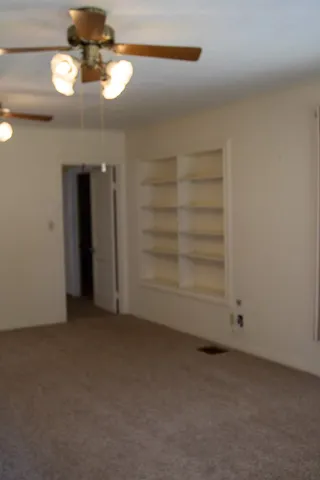 a view of empty room with a fan