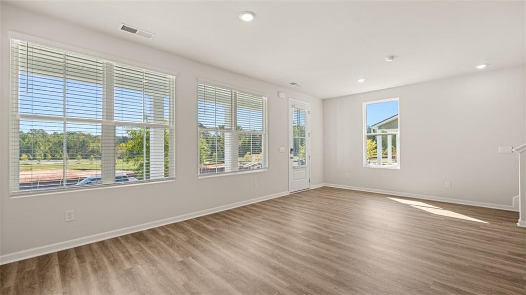 906 Stow Lane Monroe, GA 30655 - Photo 15 of 28 a view of an empty room with wooden floor and a window