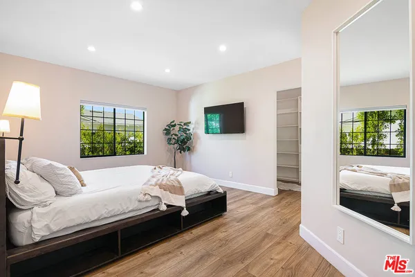a large bed sitting in a bedroom next to a window