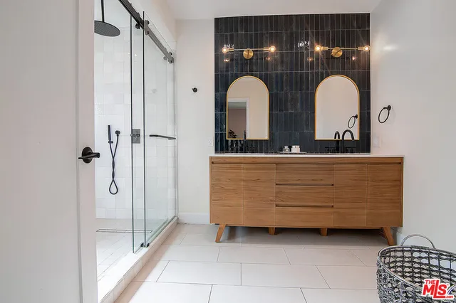 a bathroom with a tub a double vanity sink and mirror