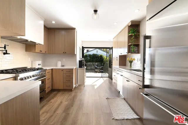 a kitchen with white cabinets appliances and wooden floor