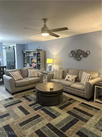 a living room with furniture a lamp and a rug