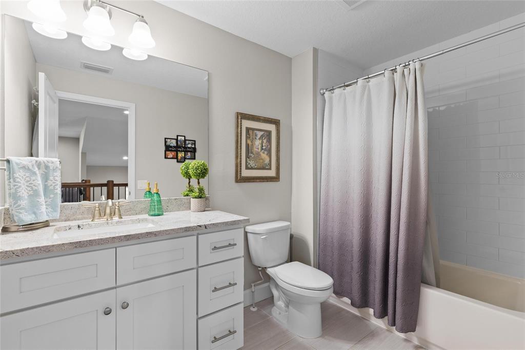 1444 Ridge Terrace Tarpon Springs, FL 34689 - Photo 25 of 30 a bathroom with a toilet a sink a mirror a vanity and window