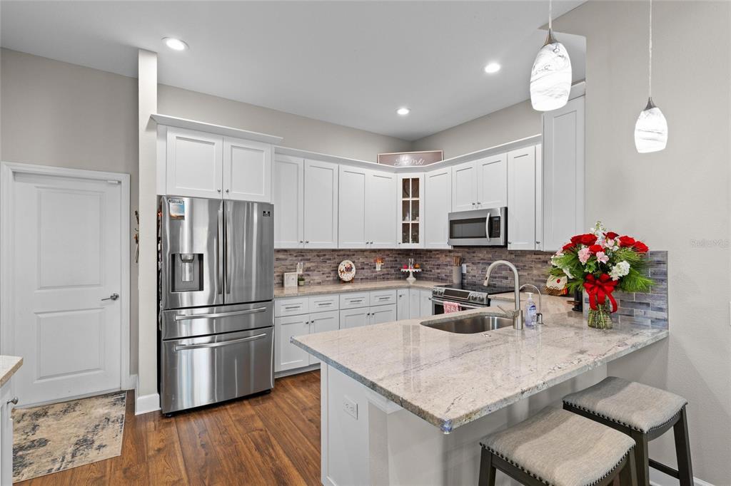 1444 Ridge Terrace Tarpon Springs, FL 34689 - Photo 8 of 30 a kitchen with a refrigerator a microwave a stove and wooden floor