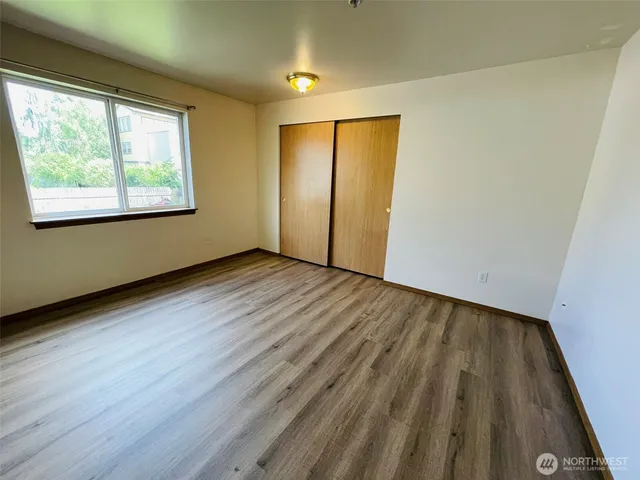 an empty room with wooden floor and a window