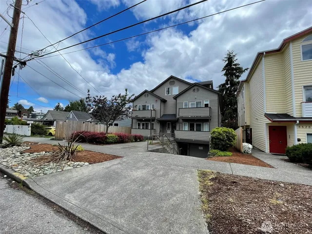 a front view of a house with a yard and potted plants