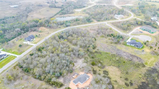 an aerial view of a house with a yard and greenery