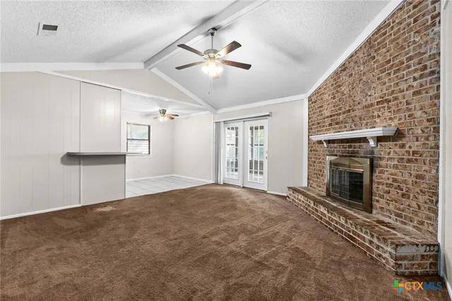 a view of empty room with fireplace and windows