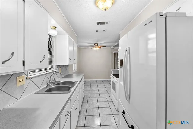 a kitchen with a sink refrigerator and microwave