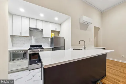 a kitchen with a sink a stove and cabinets