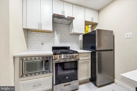 a kitchen with stainless steel appliances wooden floor sink and stove